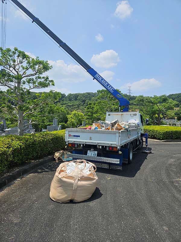 飯盛霊園の墓石撤去工事でユニック車のクレーンを使って石碑を安全に搬出する風景