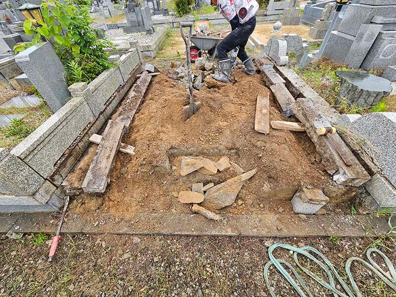石碑撤去後の手作業・台車搬出による解体風景