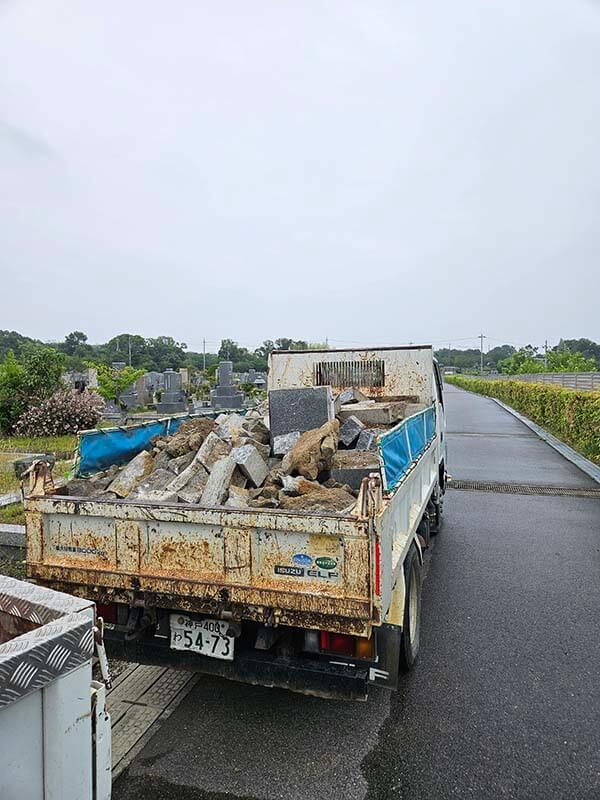 3トンダンプの荷台いっぱいに積み込まれた解体石材と出土した割栗石